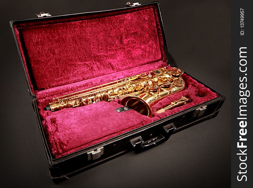 Golden saxophone in blabk case. Golden saxophone in blabk case