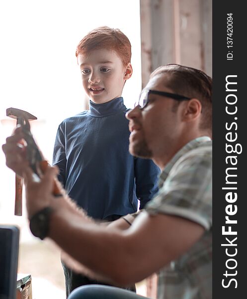 Close up.father teaches his son to use a hammer for household work