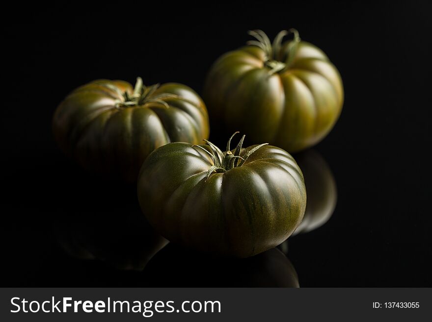 Dark brandywine tomatoes on black background