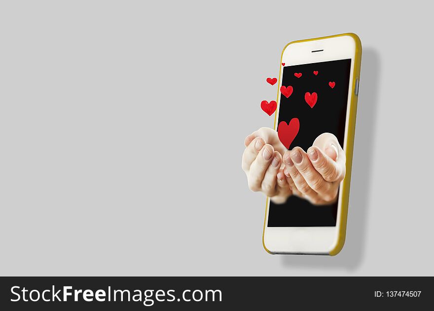 Hand holding a hand sticking out of the phone screen on an background. Concert of interaction with the phone and