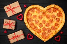 Pizza Shaped Heart With Gift Box For Valentine`s Day Romantic Concept On Rustic Dark Black Background. Top View. Flat Lay Stock Photos