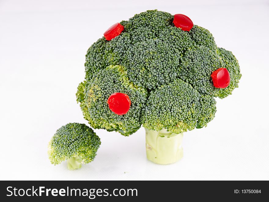 Broccoli tree with some pepper fruits on white background - symbol of growth and crop