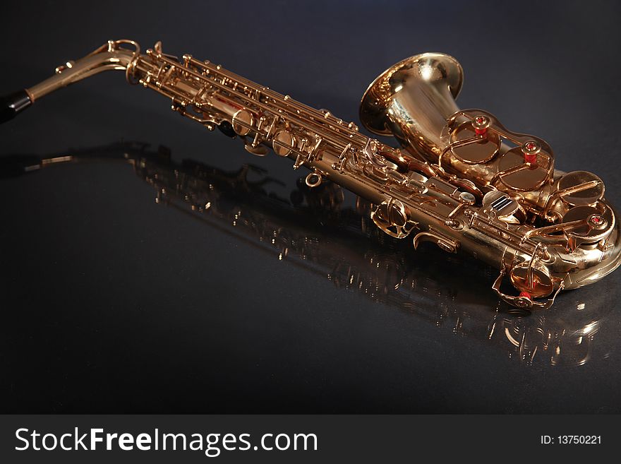 Shiny golden saxophone on black background