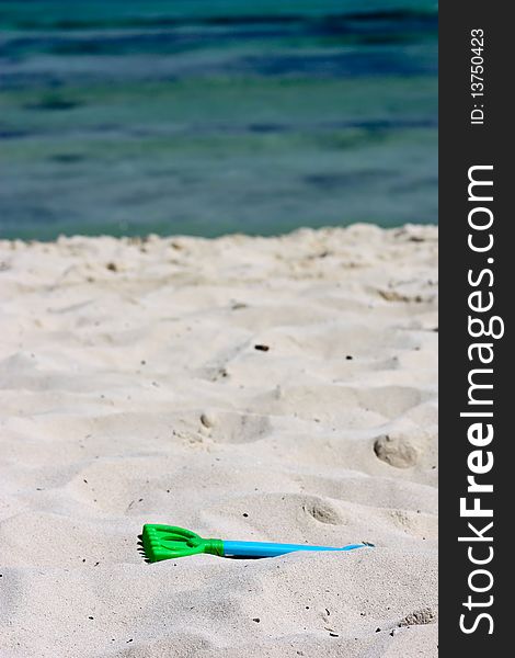 Plastic rake toy on beach near ocean