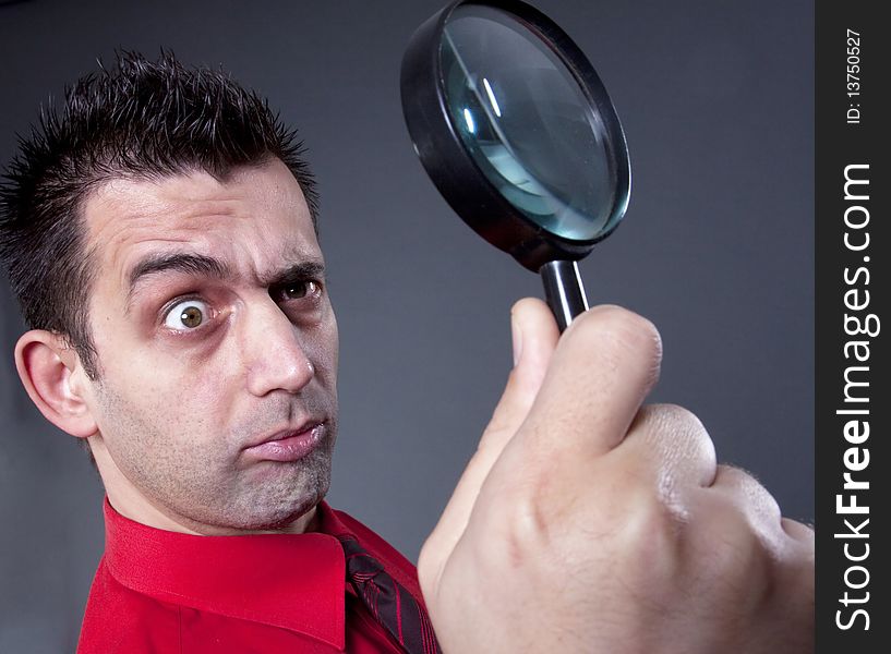 Funny businessman with magnifying glass