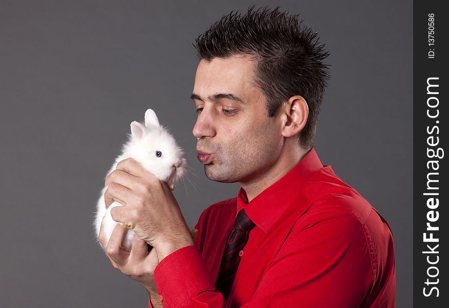 Handsome young man holding baby rabbit. Handsome young man holding baby rabbit