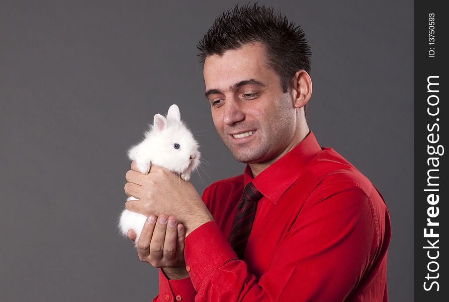 Handsome young man holding baby rabbit. Handsome young man holding baby rabbit