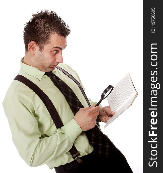 Funny businessman reading a book with magnifying glass