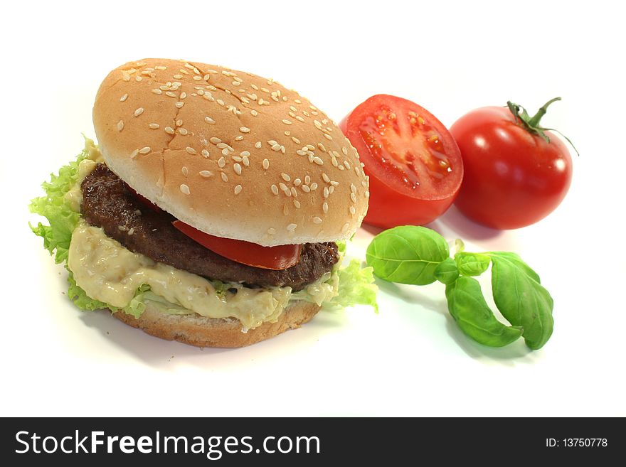Hamburger with tomato, lettuce and onions on a white background. Hamburger with tomato, lettuce and onions on a white background
