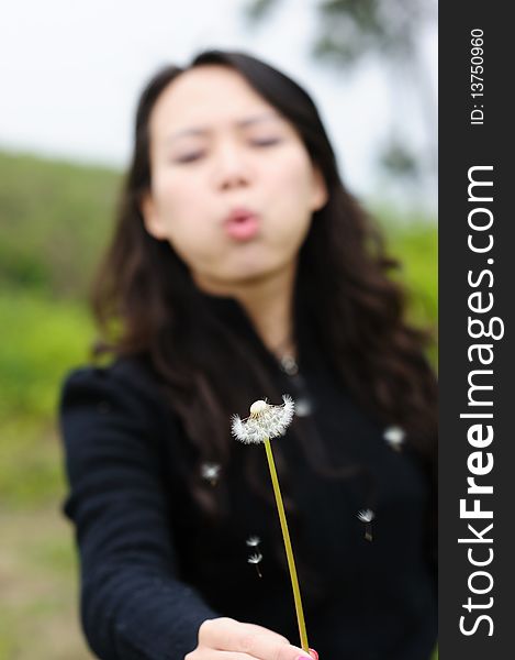 Asian woman and dandelion in spring。