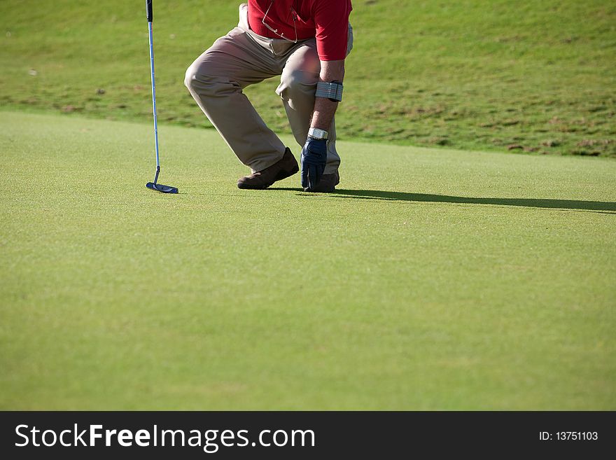 A golfer near the hole picking the ball