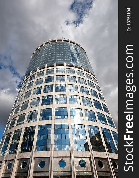 Modern glass bussines center under blue sky with clouds in summer