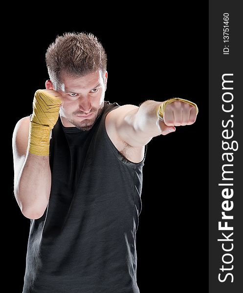 Young man in defensive boxing pose isolated on black. Young man in defensive boxing pose isolated on black