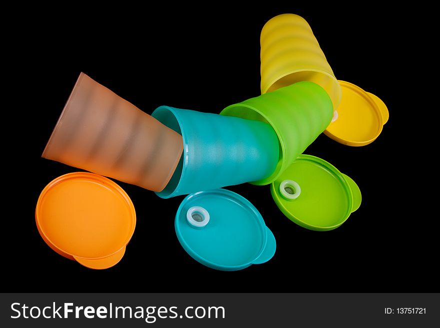 Colour plastic glasses lies in row on black background