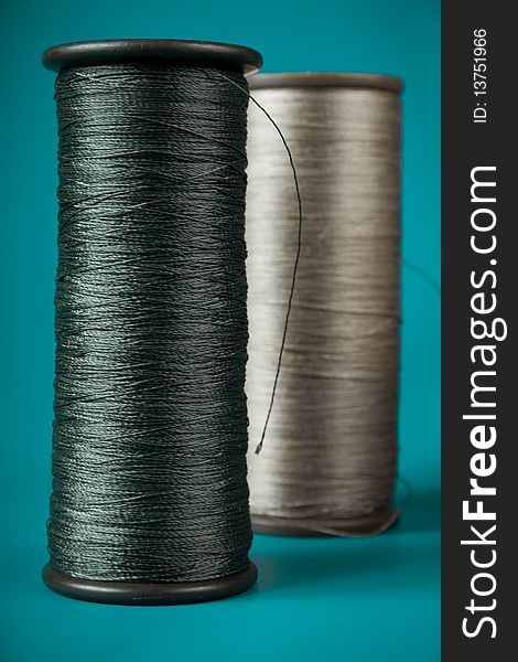 Large spools of thread on a blue background