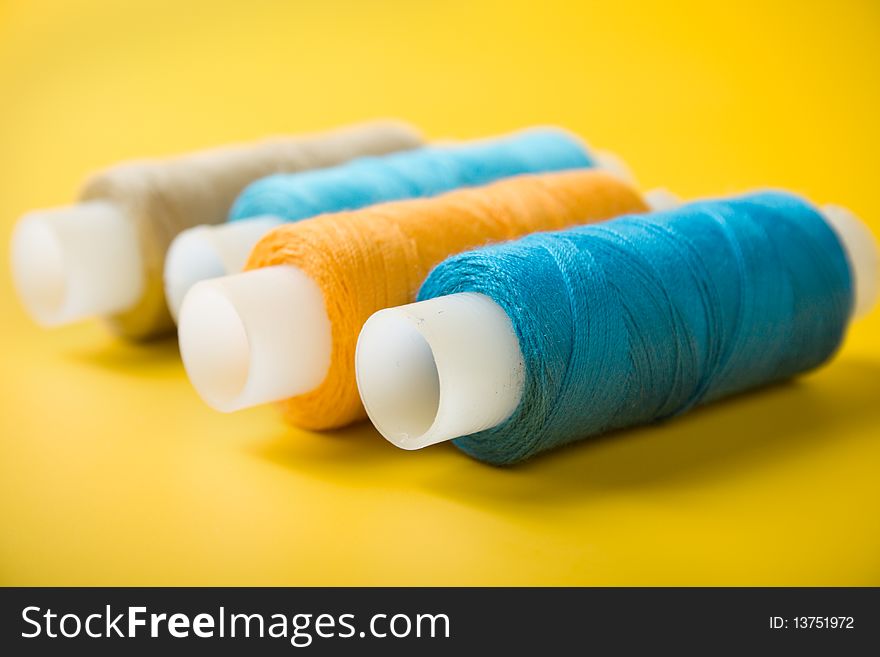 Blue, orange, white and brown spools of thread