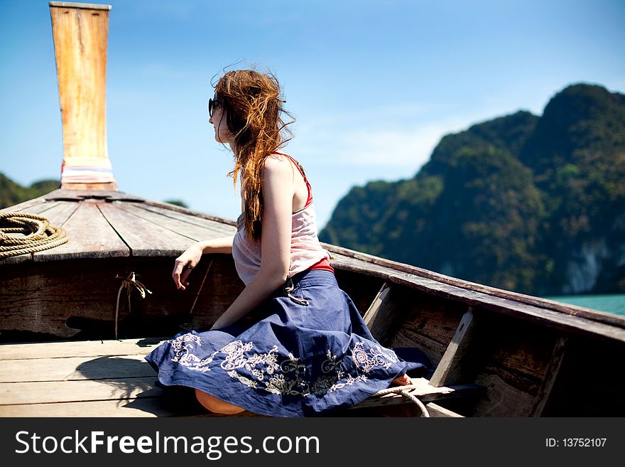 Young woman sitting on a prow of a boat. Young woman sitting on a prow of a boat