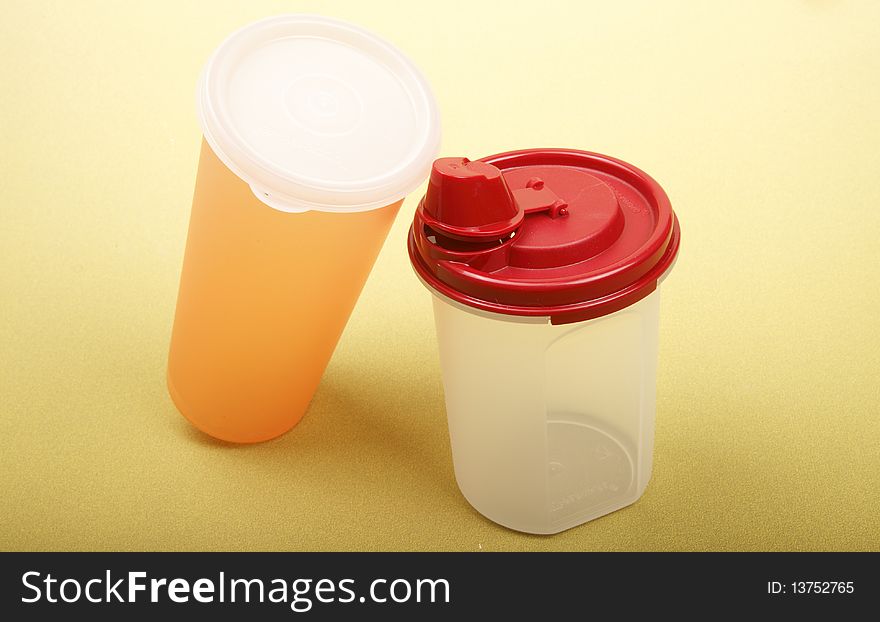 Portable plastic water cups on yellowish green background. Portable plastic water cups on yellowish green background