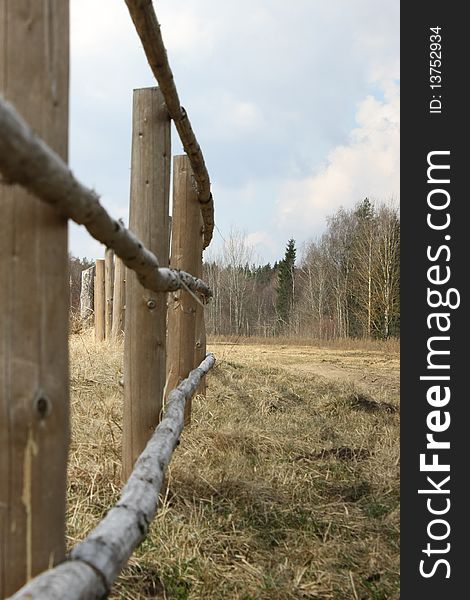 Fence from wooden poles in village