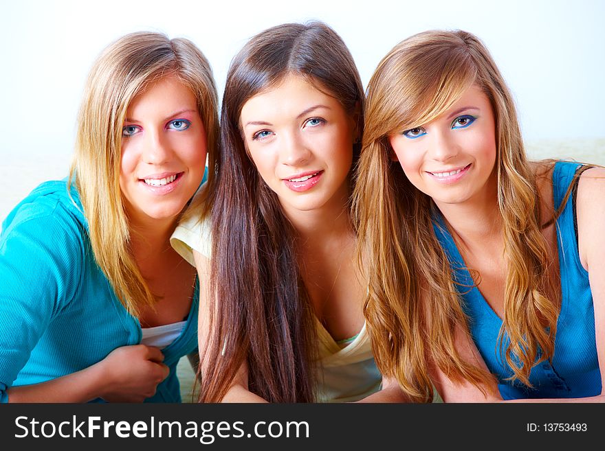 Two beautiful girls sitting on sofa in home with faces close to each other. Two beautiful girls sitting on sofa in home with faces close to each other