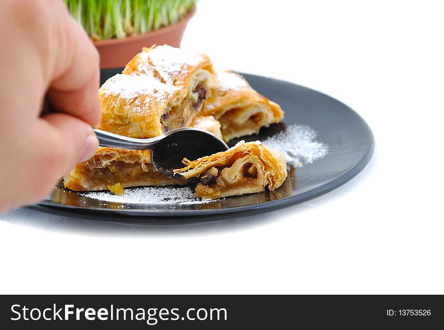 Czech apple pie on black plate and hand which cut pie