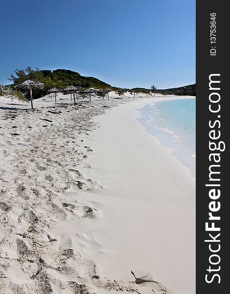 A beach scene with beautiful sand, water, and umbrellas. Island located in the Bahamas near Nassau. A beach scene with beautiful sand, water, and umbrellas. Island located in the Bahamas near Nassau