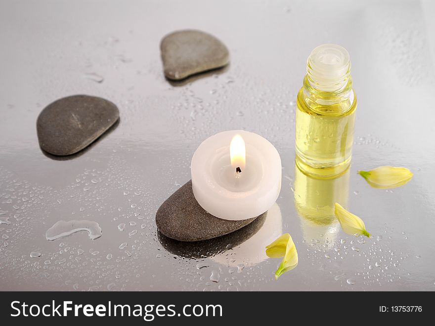 Spa conception with candle, stones and massage oil