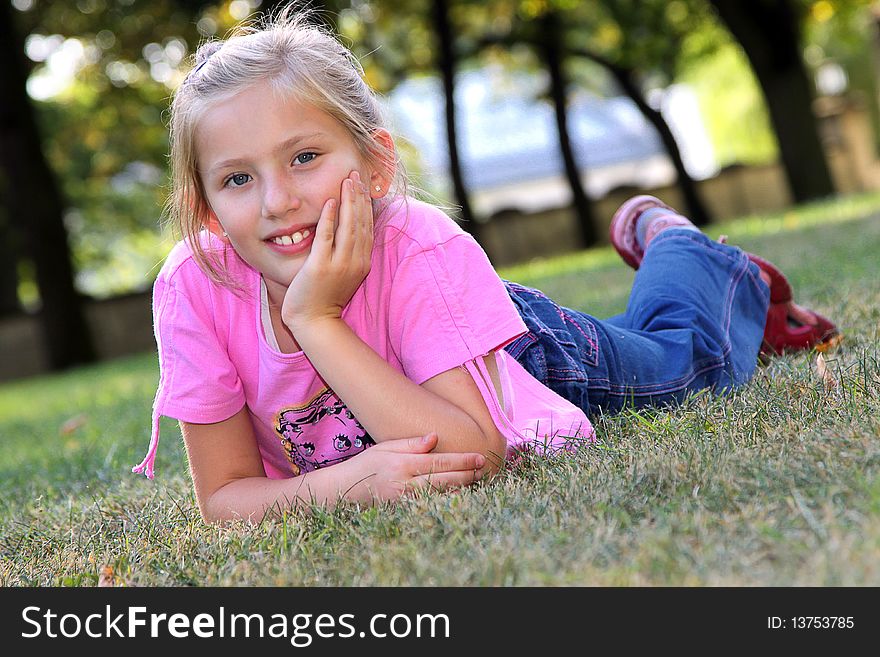 Smiling Girl On The Grass.