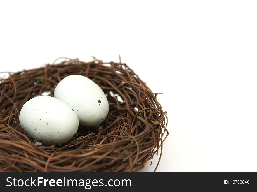 A macro shot of a bird's nest with two eggs over a white background. A macro shot of a bird's nest with two eggs over a white background.