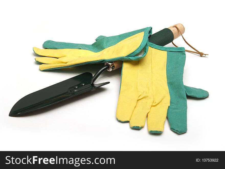 A gardeners pair of gloves and spade shovel are isolated on white. A gardeners pair of gloves and spade shovel are isolated on white.