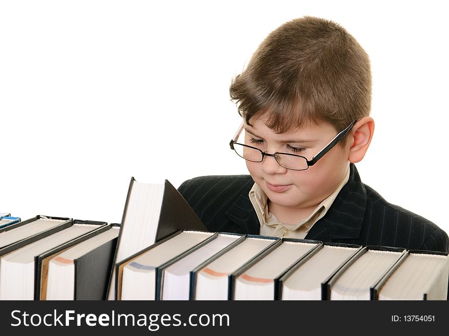 Boy wearing spectacles attentively chooses  book is isolated on white