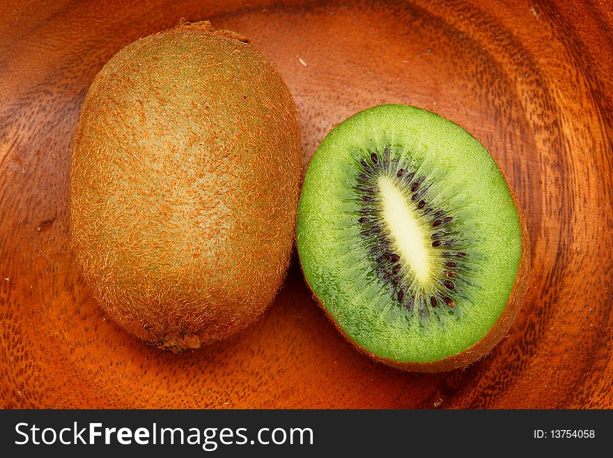 Kiwi fruit on a wooden plate.