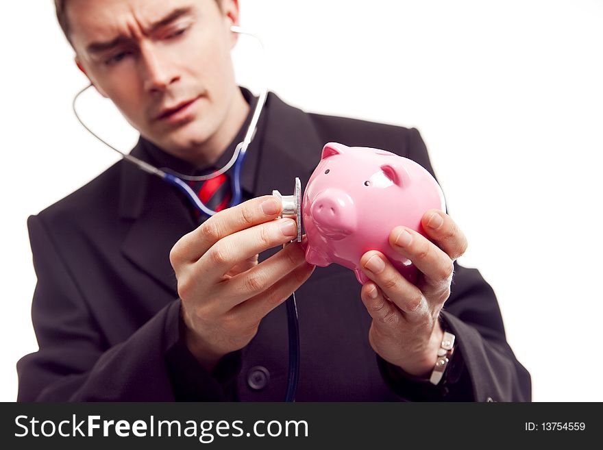 Businessman holding piggy bank and stethoscope. Businessman holding piggy bank and stethoscope