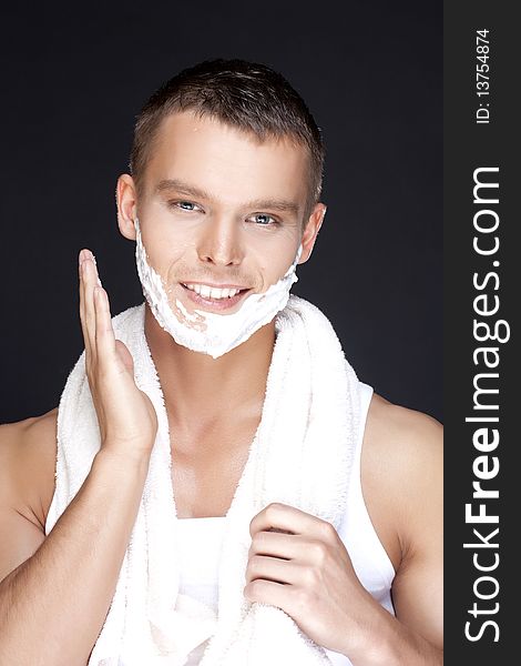 Portrait of young handsome men shaving on a black background. Portrait of young handsome men shaving on a black background