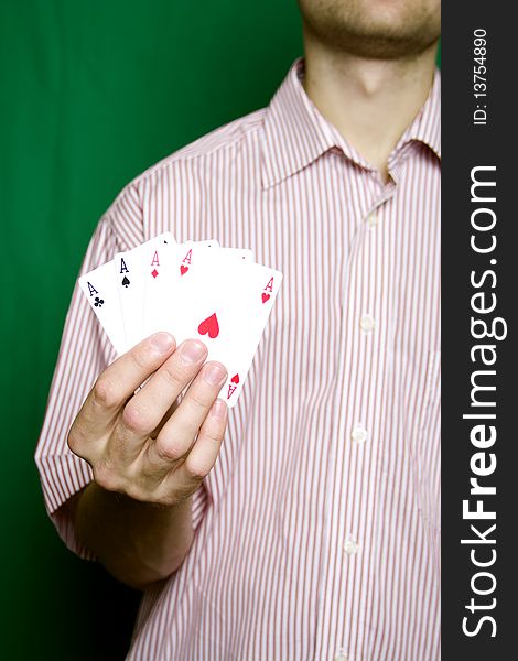 A young man in a red striped shirt, holding four aces. A young man in a red striped shirt, holding four aces