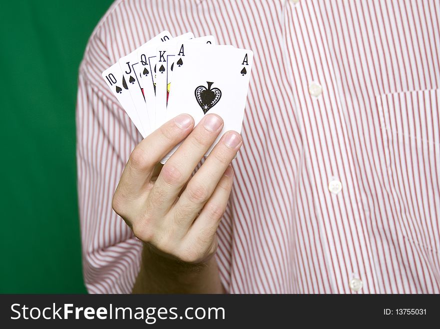 A young man in a red striped shirt, holding Royal flush