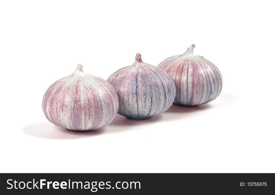 Three heads of garlic isolated on white. Focus on central garlic.
