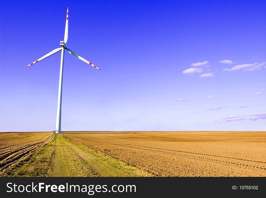 Windmill conceptual image. Windmills on plowed field.