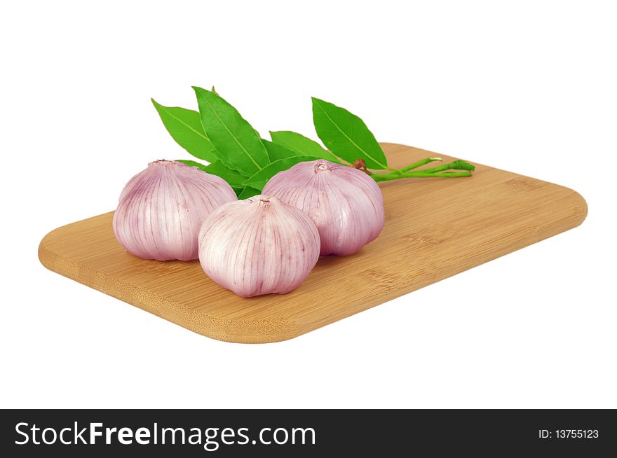Garlic on the board with a bay leaf isolated on white. Garlic on the board with a bay leaf isolated on white
