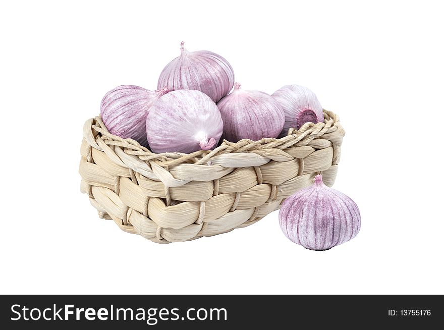 Several garlic in a wicker basket isolated on white