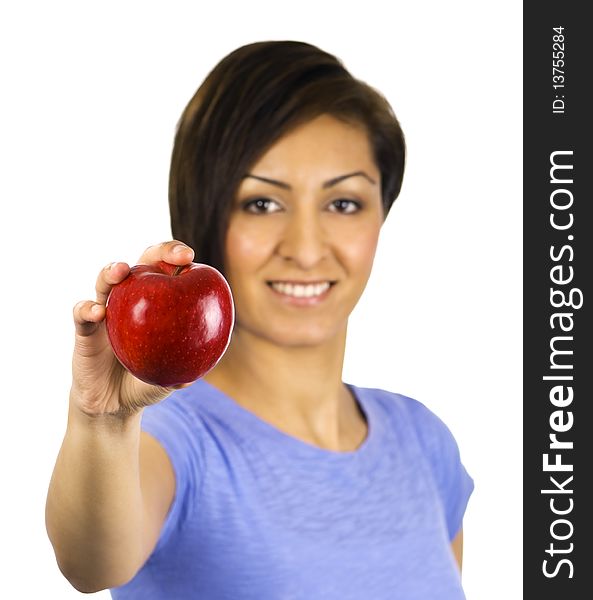 A young ethnic woman holds out a red apple. A young ethnic woman holds out a red apple.