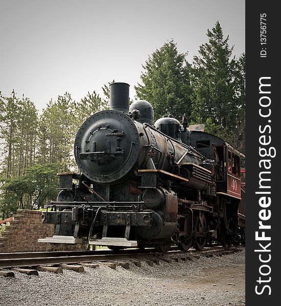 An old steam engine sitting on the tracks. An old steam engine sitting on the tracks