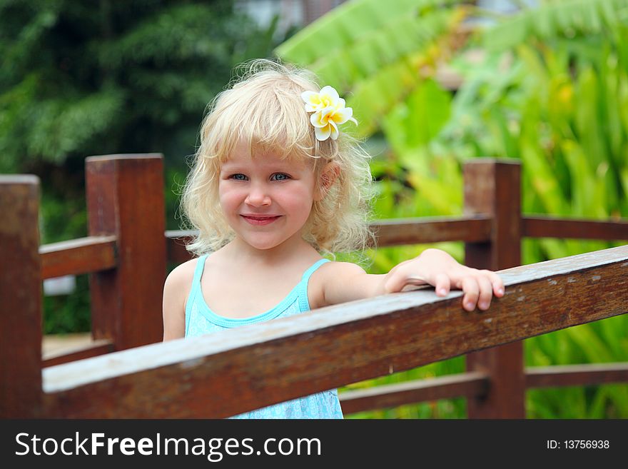 Beautiful little girl with a tropical flower