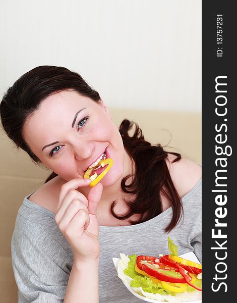 Portrait of young woman with salad at home