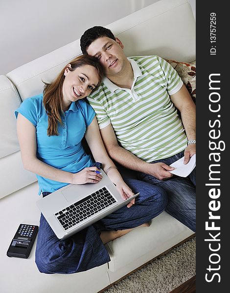 Young couple at home with  modern livingroom indoor working on laptop on house finance and planing. Young couple at home with  modern livingroom indoor working on laptop on house finance and planing