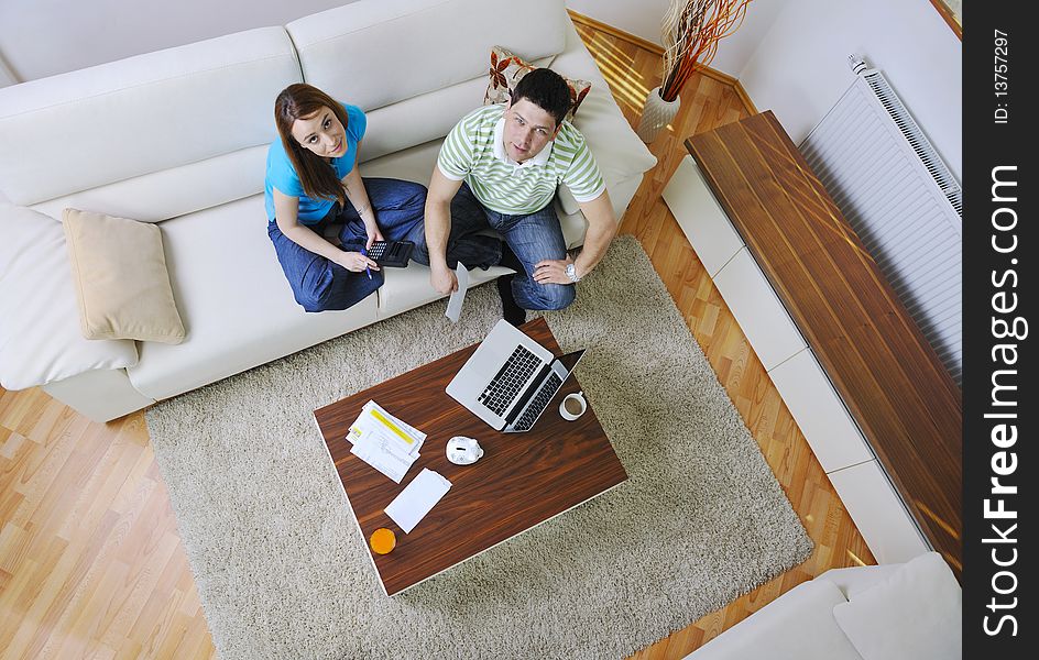 Young couple at home with modern livingroom indoor working on laptop on house finance and planing. Young couple at home with modern livingroom indoor working on laptop on house finance and planing