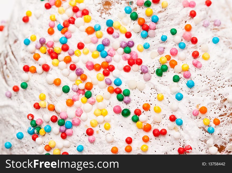 Colored balls to decorate the cake on a white glaze