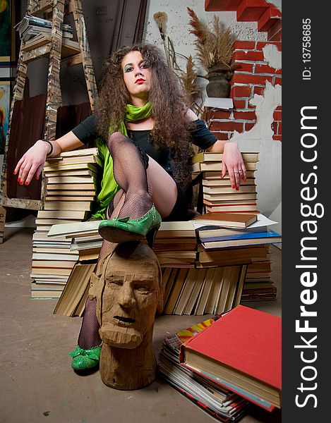 Woman sitting on armchair of books at fine arts atelier. Woman sitting on armchair of books at fine arts atelier