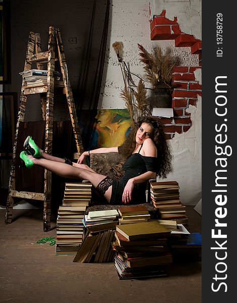 Woman sitting on armchair of books at fine arts atelier. Woman sitting on armchair of books at fine arts atelier