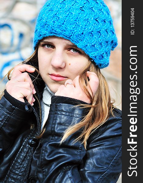 Teen girl wearing blue hat and leather jacket